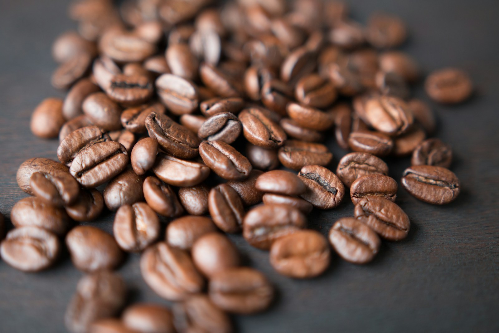Grains de café Arabica torréfiés sur fond sombre